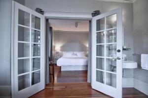 een slaapkamer met een bed en een badkamer met een wastafel bij Centralia Square Grand Ballroom and Vintage Hotel in Centralia