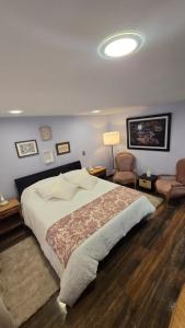 a bedroom with a large bed and two chairs at Freyja Hostal Boutique - Café Bistró in Bogotá