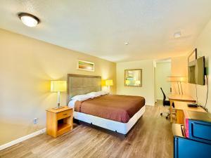 a hotel room with a bed and a desk at Woodbridge Inn By OYO Rome in Rome