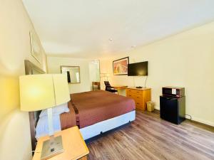 a hotel room with a bed and a desk with a lamp at Woodbridge Inn By OYO Rome in Rome