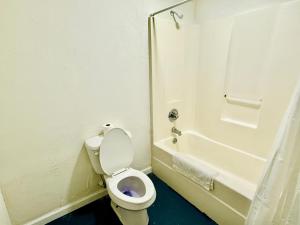 a white bathroom with a toilet and a shower at Woodbridge Inn By OYO Rome in Rome