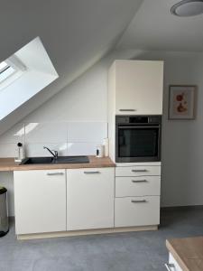 a kitchen with white cabinets and a microwave at Gemütliche Ferienwohnung in Neustadt am Rübenberge in Neustadt am Rübenberge