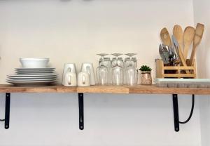 una mensola in legno con piatti e utensili di Studio bohème a La Trinité