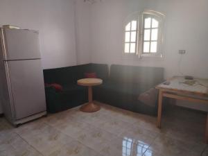 a kitchen with a small table and a refrigerator at شعبان in Beni Suef