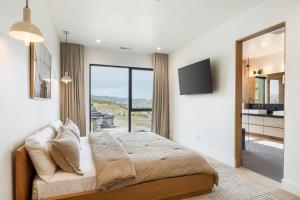 a bedroom with a large bed and a television at Stunning Luxury Interiors, Jordanelle Views, Private Hot Tub, Sauna, Elite Locale! in Francis