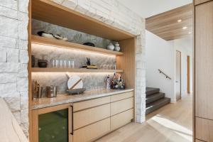 a kitchen with wooden cabinets and a stone wall at Stunning Luxury Interiors, Jordanelle Views, Private Hot Tub, Sauna, Elite Locale! in Francis +44 photos