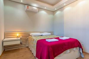 a bedroom with a bed with a red blanket at Imóvel bem localizado em Canela, cobertura in Canela