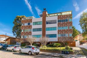 a building with cars parked in front of it at Imóvel bem localizado em Canela, cobertura in Canela