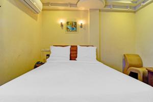 蒂鲁奇奇拉帕利Hotel O Royal的卧室里有一张白色的大床和一把椅子