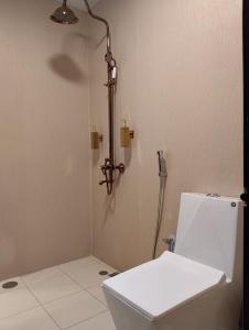 ein Badezimmer mit weißer Toilette und Dusche in der Unterkunft Ahmadia Heritage Hiba Guest House - Built in 1916 - Al Ras Metro Station in Dubai