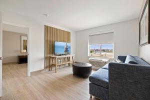 a living room with a couch and a tv at Kompose Boutique Hotel Houston Cy-Fair in Houston