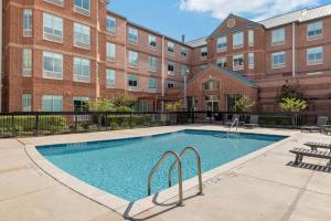 a swimming pool in front of a brick building at Kompose Boutique Hotel Houston Cy-Fair in Houston