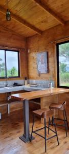 a kitchen with a large wooden table in a cabin at Dulces Momentos PZ  +3 photos