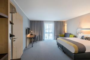 a hotel room with a bed and a desk at Holiday Inn Express Gütersloh by IHG in Gütersloh +31 photos