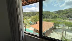 a window with a view of a resort at Pousada do Lago in Guaramiranga