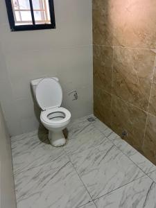 a bathroom with a toilet and a tiled floor at Glides studio in Lekki