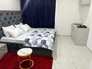 a small bedroom with a bed and a stool at Glides studio in Lekki