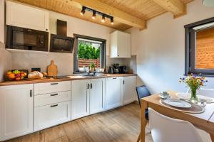 Una cocina con gabinetes blancos y una mesa de comedor. en Dream Home 600m2 EV WiFi600 PlaySt Kominek Las10min, en Polanica-Zdrój