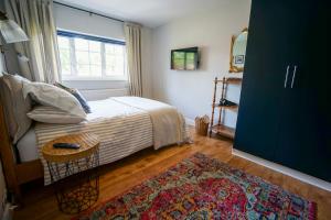 a bedroom with a bed and a window and a rug at Beautiful 2 Bed Home with Spacious Garden in Shephall