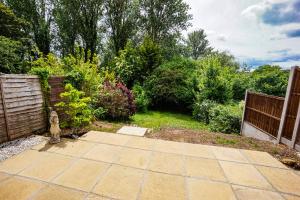 a garden with a fire hydrant next to a fence at Beautiful 2 Bed Home with Spacious Garden in Shephall