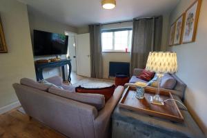 a living room with two couches and a television at Beautiful 2 Bed Home with Spacious Garden in Shephall +18 photos