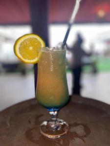 a drink sitting on a table with an orange slice at Mai Hotel in Conakry +25 photos