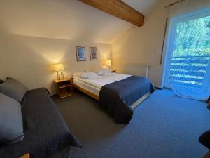 een slaapkamer met twee bedden en een groot raam bij Apartamenty Czyrna przy Gondoli in Szczyrk