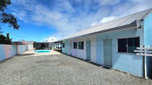 a building with a swimming pool in front of it at Pousada Bahamas Sc in Penha