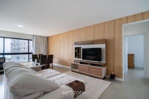 a living room with a couch and a tv at Desfrute do melhor de Perequê a 150m do mar! CLE in Perequê