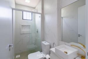 a white bathroom with a toilet and a shower at Desfrute do melhor de Perequê a 150m do mar! CLE in Perequê +17 photos