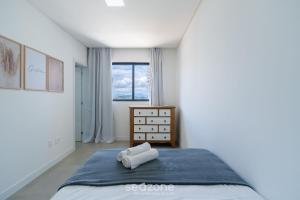 ein weißes Schlafzimmer mit einem Bett und einem Fenster in der Unterkunft Desfrute do melhor de Perequê a 150m do mar! CLE in Perequê