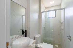 ein weißes Bad mit einem WC und einer Glasdusche in der Unterkunft Desfrute do melhor de Perequê a 150m do mar! CLE in Perequê + 35 Fotos