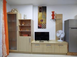 a living room with a tv on a wooden entertainment center at Maradentro in Bueu