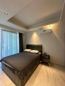 a bedroom with a large bed and a window at Cebeci tower in Mahmutlar