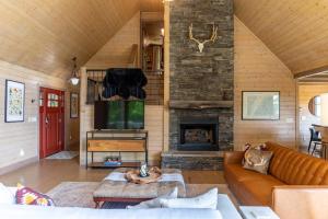 ウェスト・ジェファソンにあるQueen Ridge Cabinのソファと暖炉のあるリビングルーム
