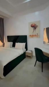 a bedroom with a bed and a desk and a chair at Smartlinks apartments in Ikota