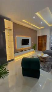 a living room with a couch and a tv at Smartlinks apartments in Ikota