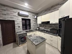a kitchen with white cabinets and a washer at City Escape in Ikuata
