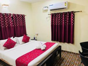 a bedroom with a large bed with red curtains at Villa funk monk - swimming pool in Kuilapayam