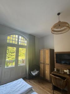 a bedroom with a bed and a window and a door at Waldhotel Bad Essen in Bad Essen
