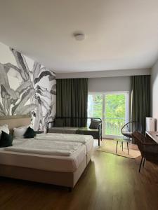 a bedroom with a bed and a large window at Waldhotel Bad Essen in Bad Essen