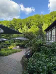 a patio with umbrellas next to a building at Waldhotel Bad Essen in Bad Essen