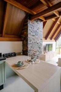a kitchen with a table and a stone wall at Serra e Sossego in Annitapolis