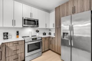 uma cozinha com armários brancos e uma geladeira de aço inoxidável em Peaceful 2BR by the Bay Pool and Coastal Vibes em Apollo Beach