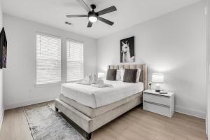 um quarto branco com uma cama e uma ventoinha de tecto em Peaceful 2BR by the Bay Pool and Coastal Vibes em Apollo Beach