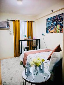 a room with a bed and a table with flowers on it at Norman Condominium Unit Rental Sea View in Dumaguete