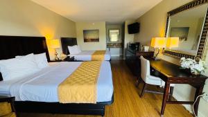 een hotelkamer met twee bedden en een bureau bij Hotel Monte Carlo in Kissimmee