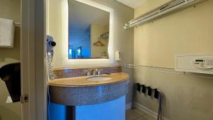 un bagno con lavandino e specchio di Hotel Monte Carlo a Kissimmee