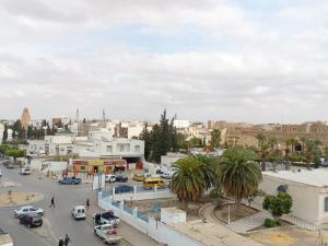 a city with cars parked in a parking lot at immeuble brini in Kairouan +17 photos