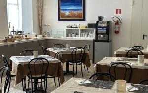 a restaurant with tables and chairs in a kitchen at Hotel Mirage in Lido di Jesolo +31 photos